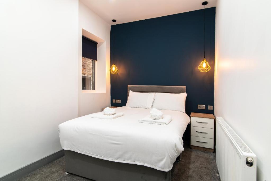 德比1BR Derby City Centre Flat 1 - Charnwood Flats的卧室配有一张白色大床和蓝色的墙壁
