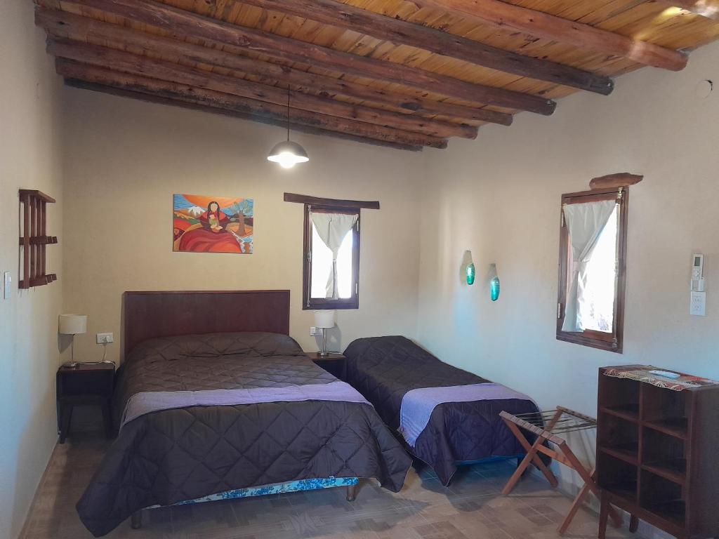 乌尼翁镇Cabañas Cañones del Triásico的配有木天花板的客房设有两张床。