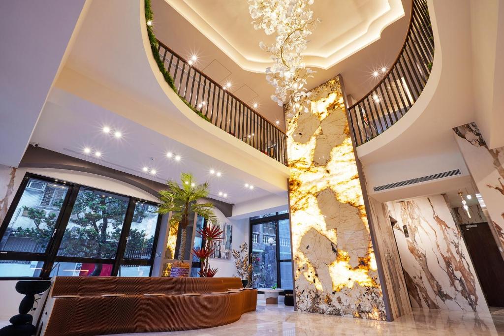 高雄星澄風旅 Zela Design Hotel的大堂设有螺旋楼梯和带绘画的墙壁