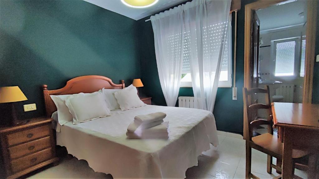 巴雷罗斯Habitaciones CASA BRAIS的卧室配有1张床、1张桌子和1把椅子