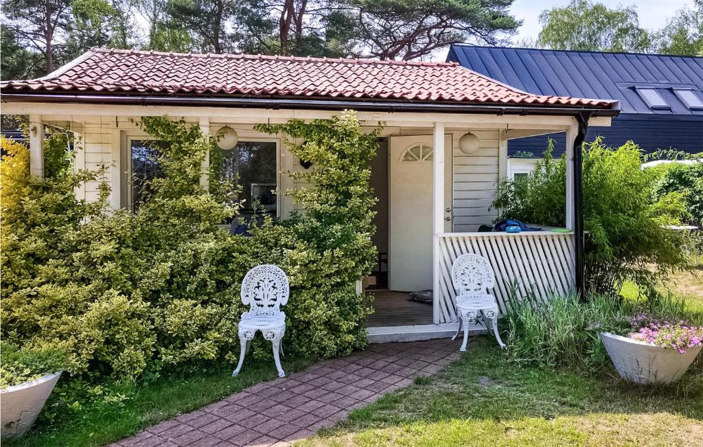 赫尔湾1 Bedroom Amazing Home In Hllviken的院子内带两把椅子的小房子