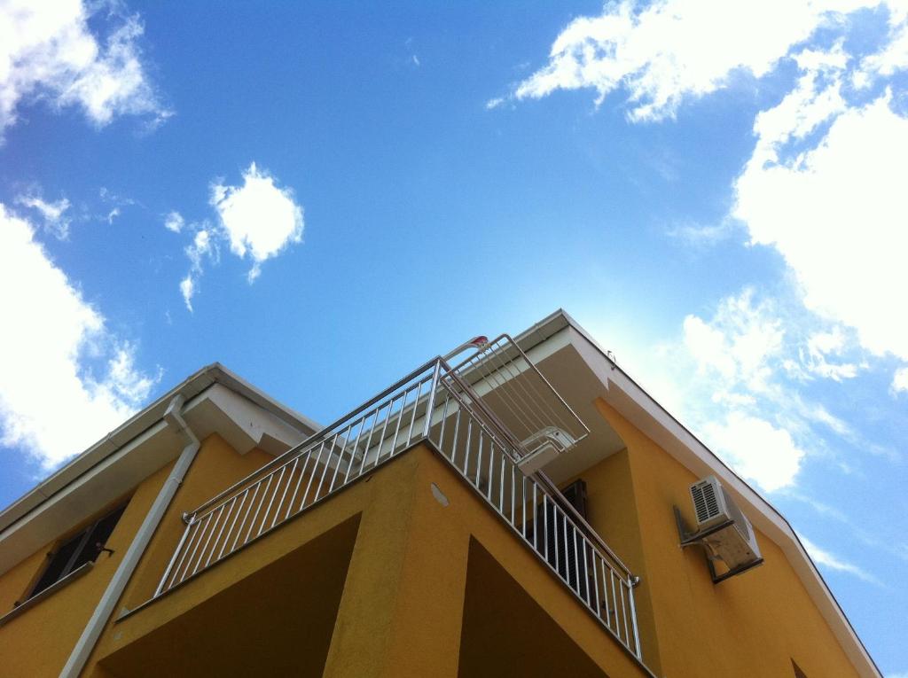 马林斯卡Apartments Leona & David的黄色的建筑,上面有楼梯
