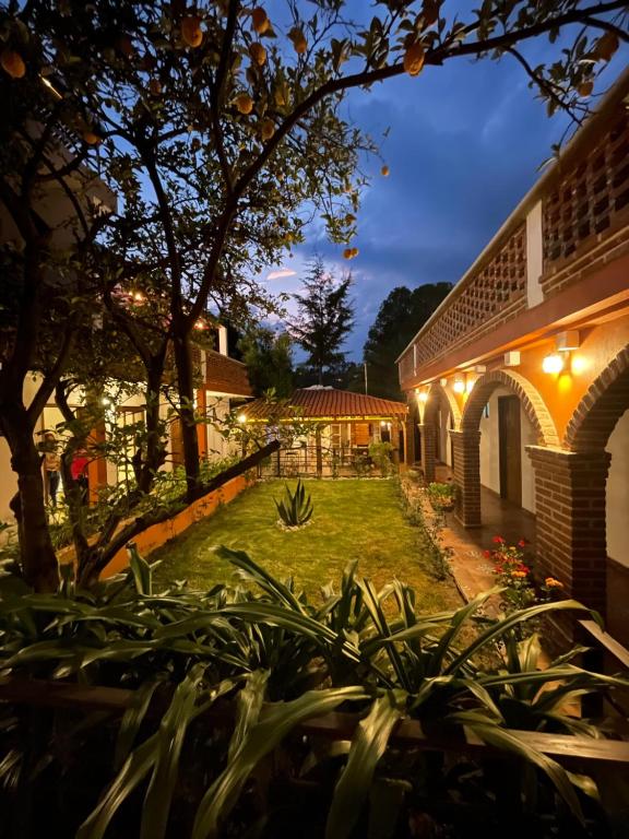 底拉斯卡拉Hotel RioMiel Tlaxcala的夜晚有灯光的房子的庭院