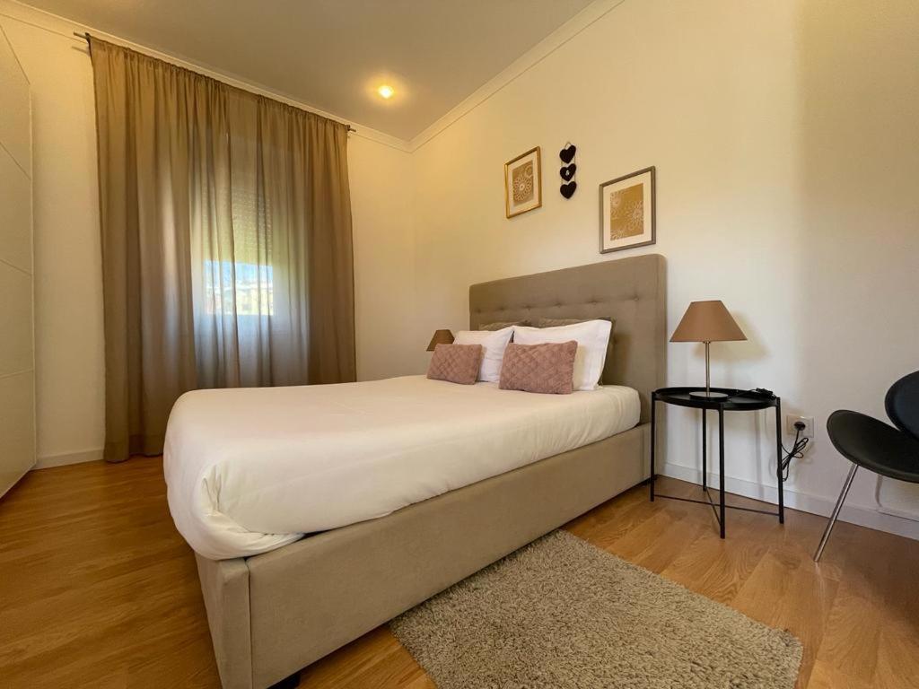 波尔图Burgães II Apartment的卧室配有一张大白色床和窗户