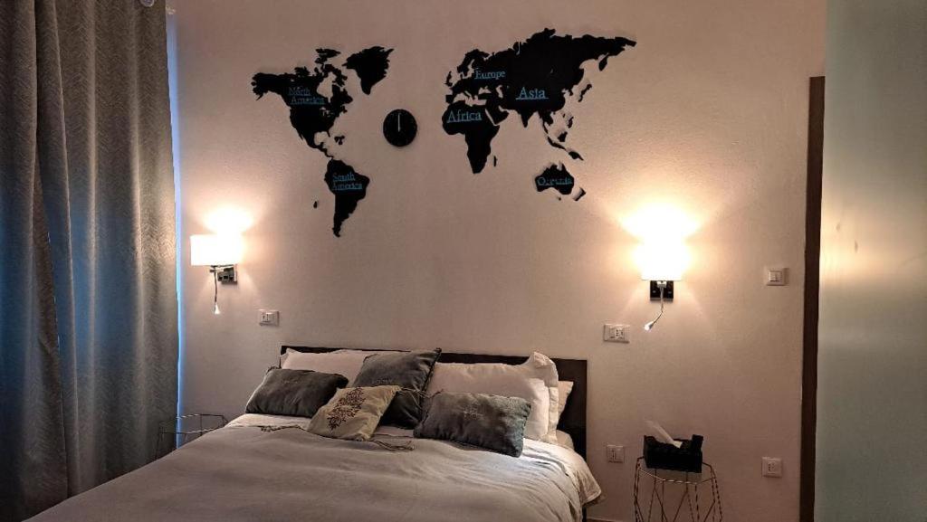 比萨MIGU POINT Pisa的卧室配有一张挂着世界地图的床