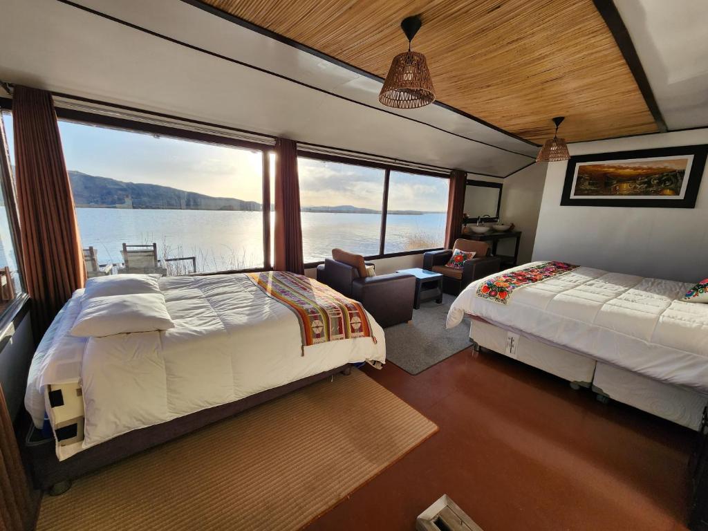 普诺Casitas del Titicaca Peru的一间卧室设有两张床,享有水景