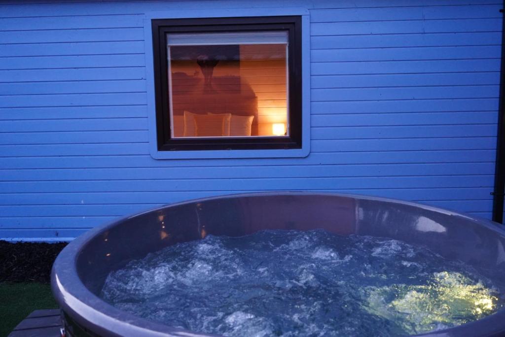 BaltinglassWest Wicklow Glamping with Hot Tub的窗户旁装满水的大浴缸