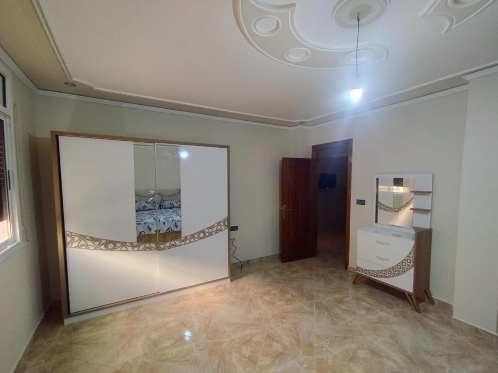 appartement joliment meublé pour 4/5 personnes à Imzouren的一间设有大玻璃门和镜子的房间