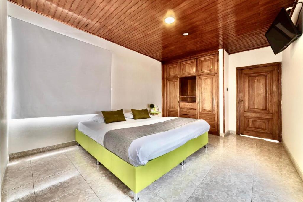 波哥大Hotel Quintas de Normandia的一间卧室设有一张床和木制天花板