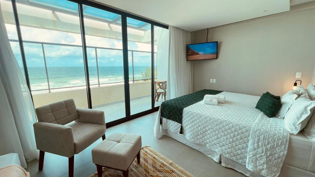 嘎林海斯港Rudá Boutique Hotel Porto de Galinhas的一间卧室配有一张床,享有海景