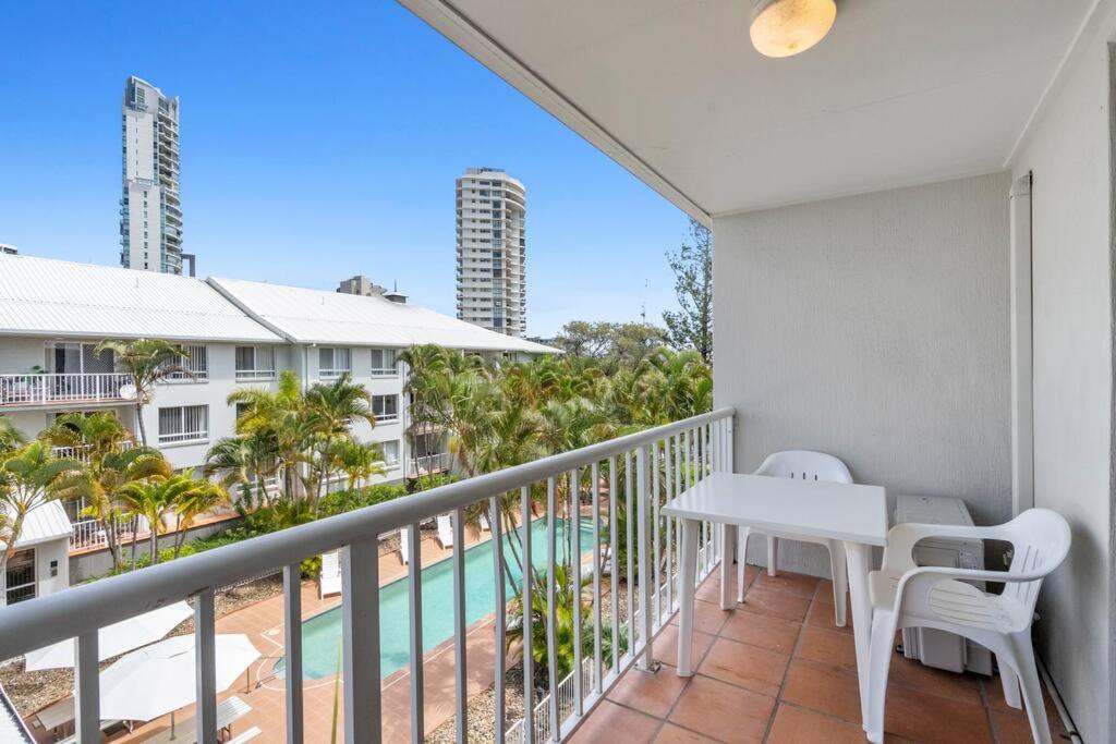 黄金海岸Bay Lodge - Private Apartments的一个带桌椅的阳台和一个游泳池