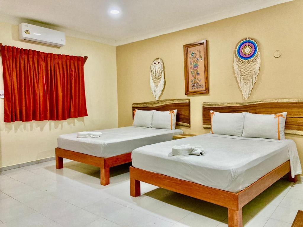 巴利亚多利德Casa Yaxkin的一间卧室设有两张床和红色窗帘