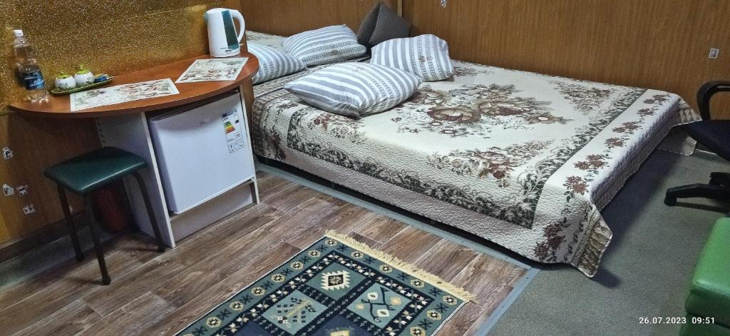 阿拉木图Apartment in a guest house的小房间设有床、桌子和柜台