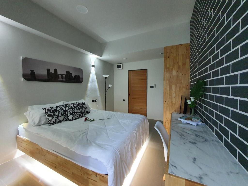 北榄府Irich Residence สาขา สำโรงใต้的一间卧室设有一张床和砖墙