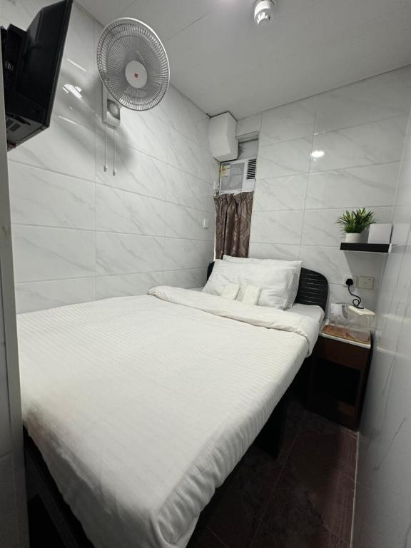 香港Mandarin Guest House的小房间设有白色的床和风扇