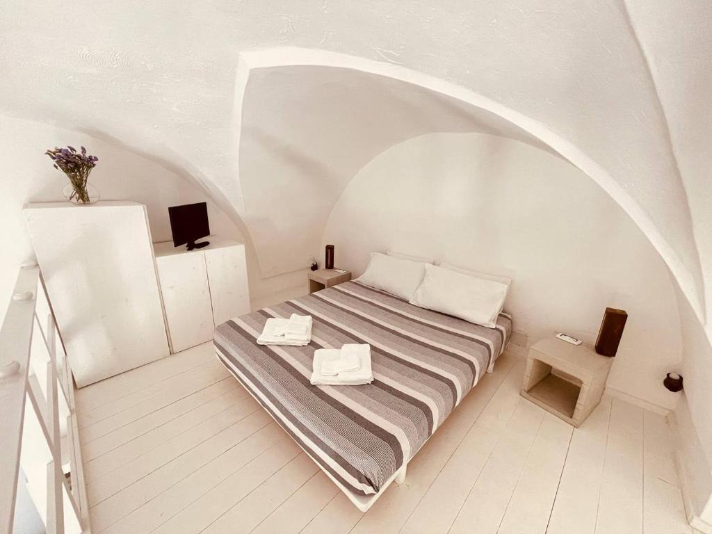 马蒂诺La Corte Bianca的一间带床和拱门的小卧室