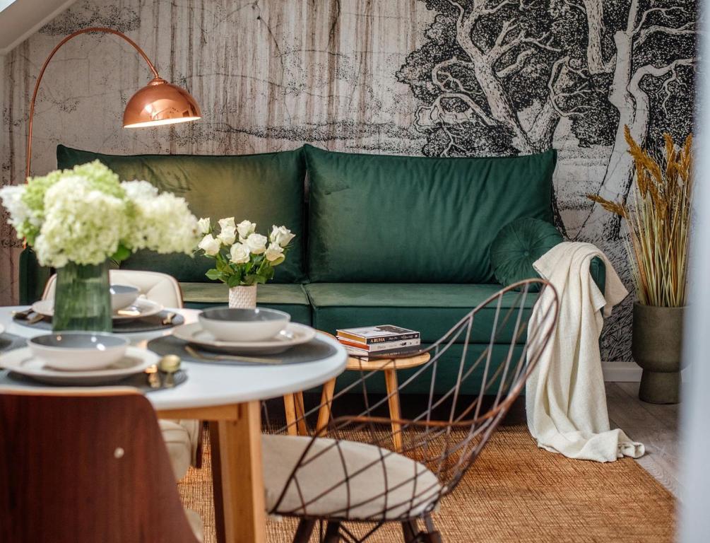 维斯普雷姆Belváros Apartman的客厅配有绿色沙发和桌子