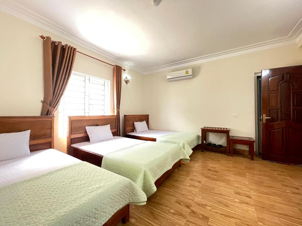 格卢市社Trường Sa Hotel Cửa Lò Beach的带三张床和窗户的客房