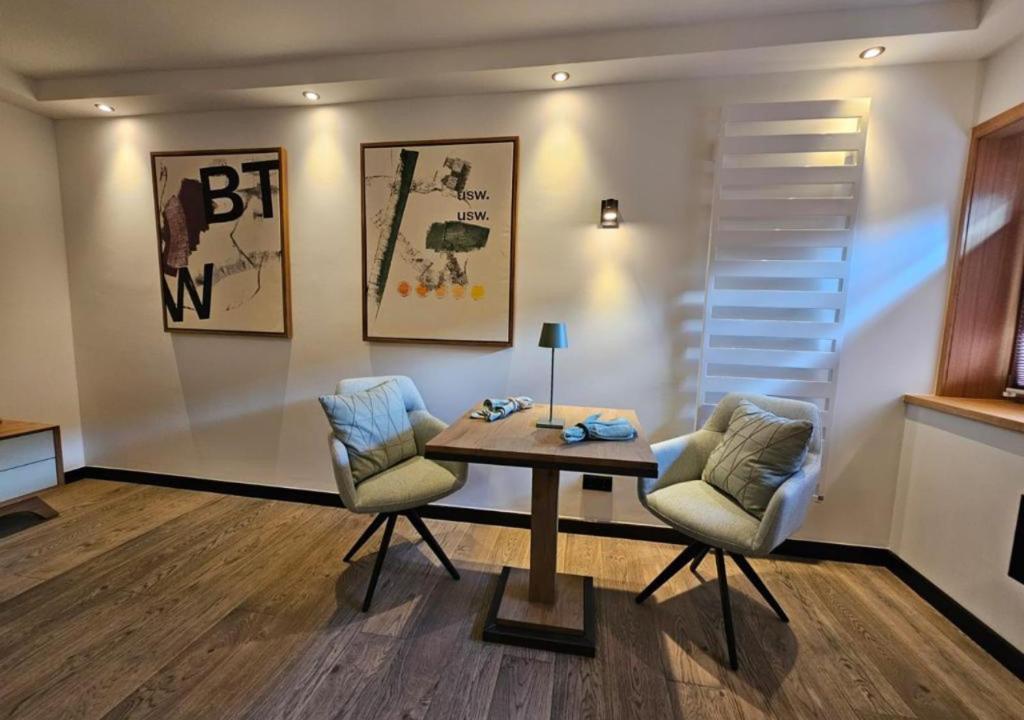 坎彭Boutique Suites Sylt - Kliffkante - Opening August 2023的客厅配有桌子和两把椅子
