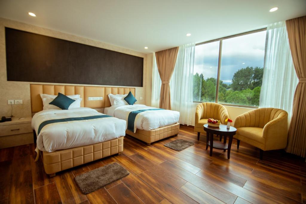 加德满都Hotel Black Diamond - Inside Airport的酒店客房带两张床和一张桌子以及椅子。