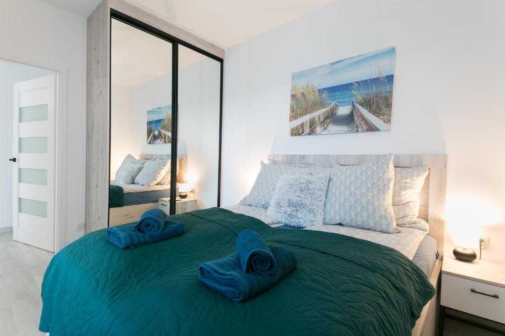 格里兹鲍SUNSET RESORT APARTAMENT的一间卧室配有一张大床,上面有蓝色的毛巾