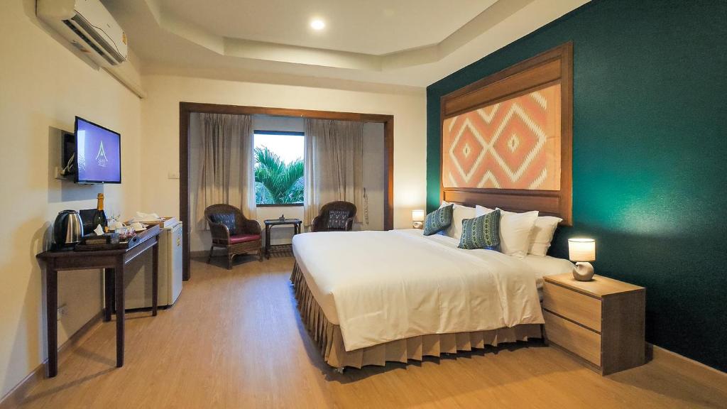 清莱Siam Avari Hotel, Chiang Rai的酒店客房设有一张大床和一台电视。