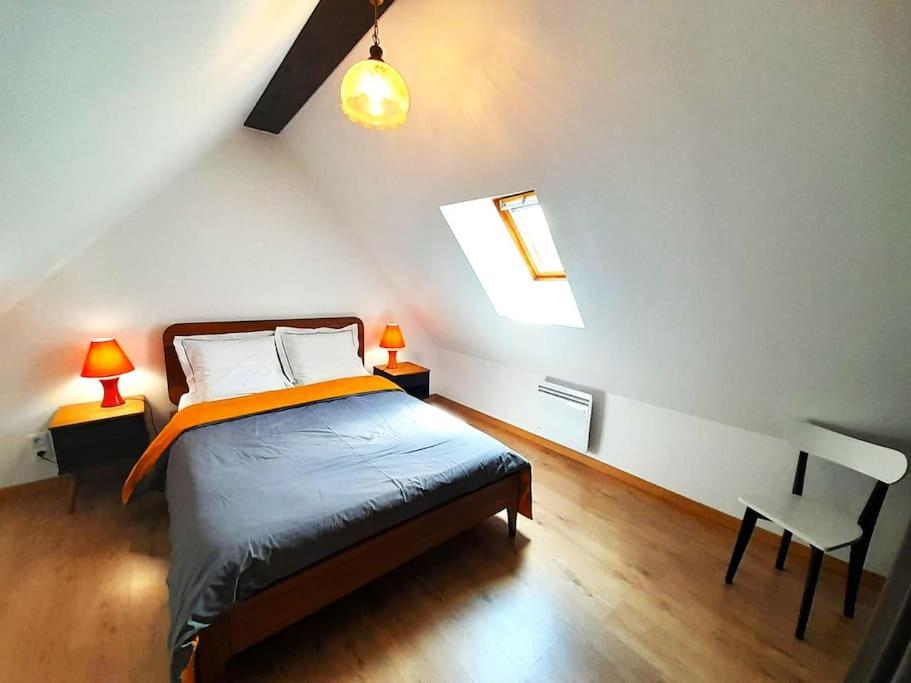LevrouxGite Porte de Champagne Levroux的一间卧室配有一张床、两盏灯和一把椅子