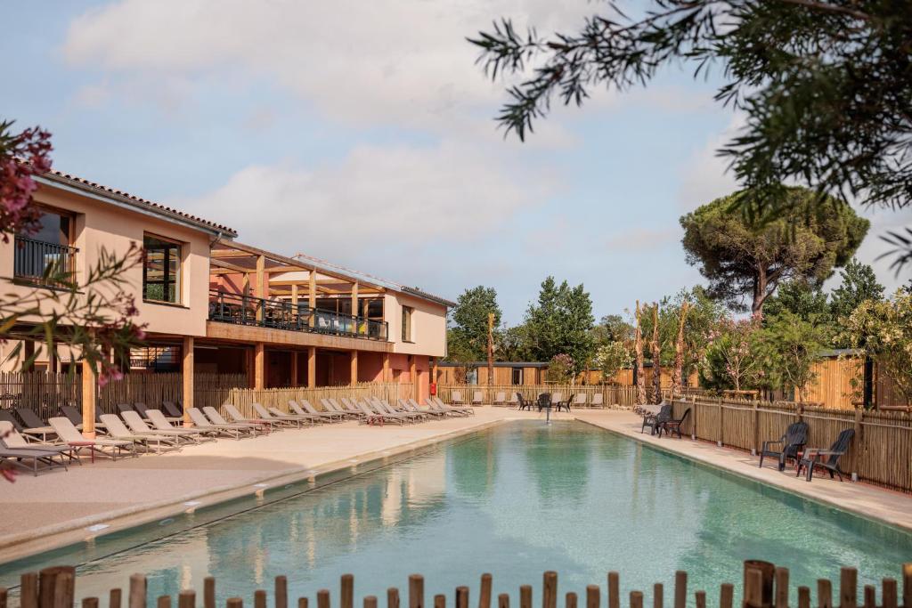 勒格劳德阿格德Beach Resort Agde的一座带椅子的游泳池以及一座建筑