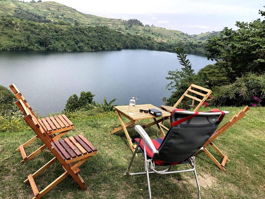 波特尔堡Baranko Villa的湖畔的两把椅子和一张桌子