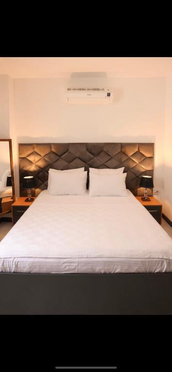 阿拉恰特Lion Otel Alaçatı的一间卧室配有一张带两盏灯的大型白色床。