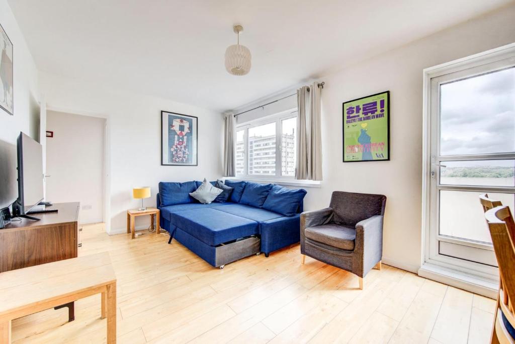 伦敦GuestReady - Penthouse Flat in Trendy Peckham的客厅配有蓝色的沙发和椅子