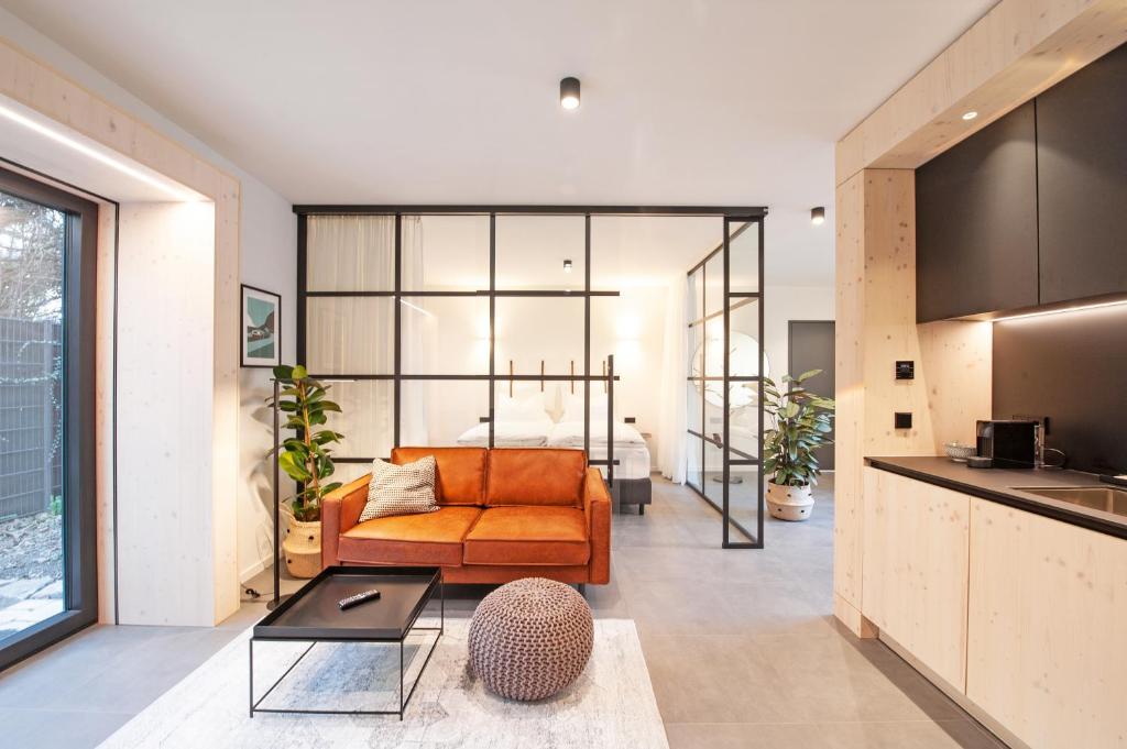 斯图加特Mono Design Apartments的一个带橙色沙发的开放式客厅和一个厨房
