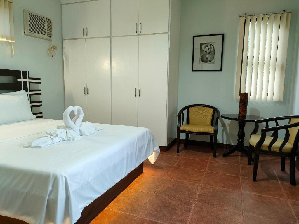 邦劳DMC2 Residence Panglao的一间卧室配有两张床、一张桌子和一把椅子