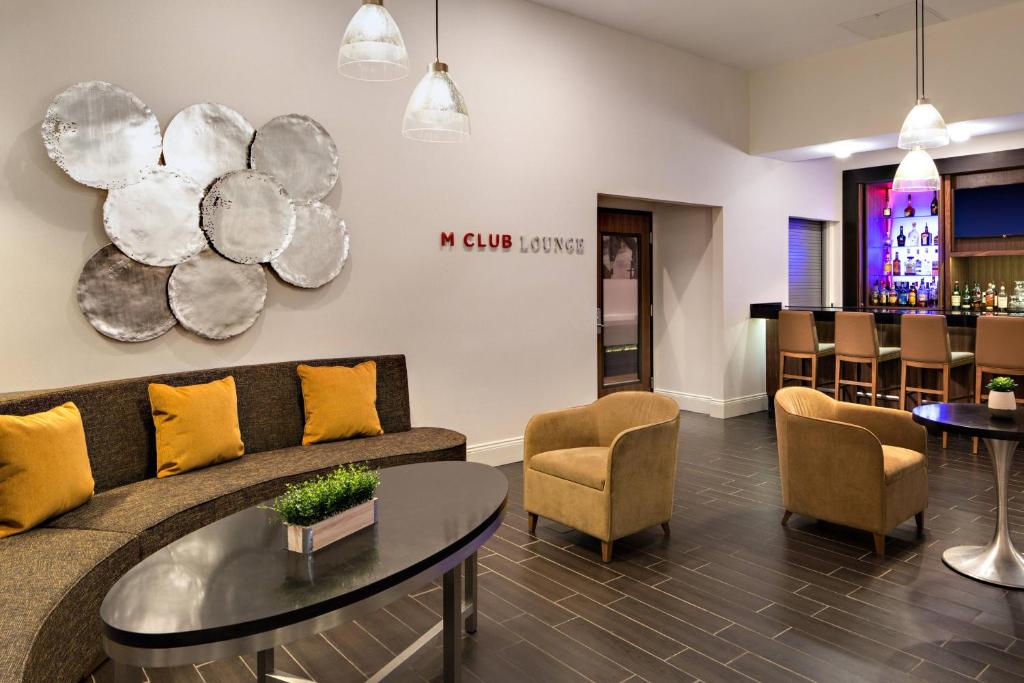 休斯顿南休斯敦霍比机场万豪酒店的带沙发和桌子的客厅以及酒吧。