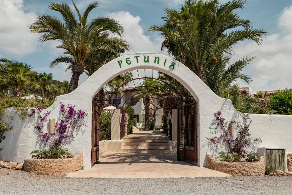 卡拉瓦德亚Petunia Ibiza, a Beaumier hotel的鲜花和棕榈树度假村的入口