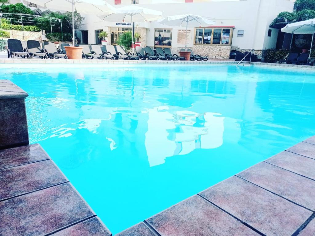 圣保罗湾城圣安东公寓式酒店的酒店内有一个蓝色的游泳池
