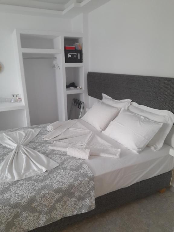 安提帕罗斯岛Sand rooms Antiparos的白色的床、白色床单和枕头