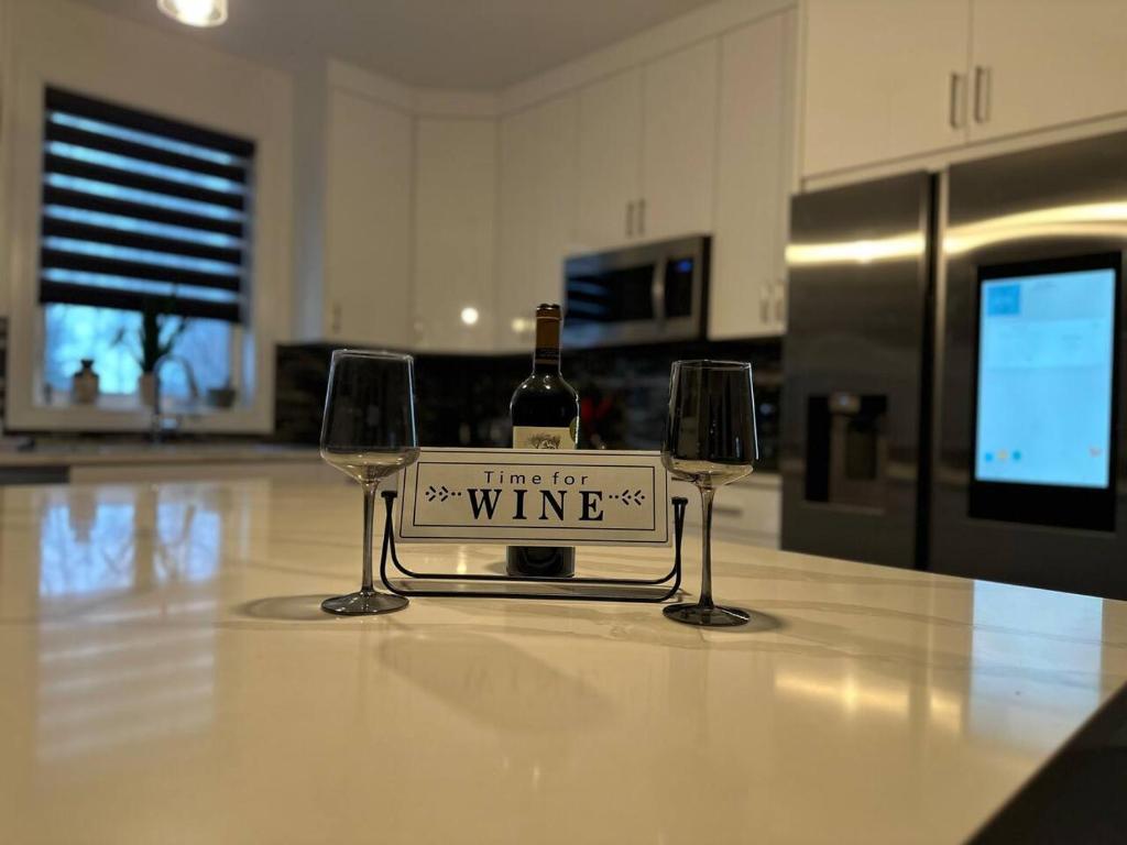 RockportHeadlands Airbnb的两杯酒杯之间坐上一瓶葡萄酒