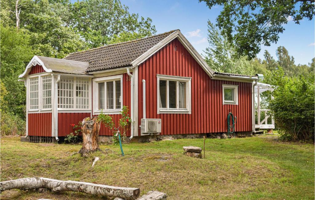 龙讷比Gorgeous Home In Ronneby With Kitchen的一座有树的院子中的红色房子