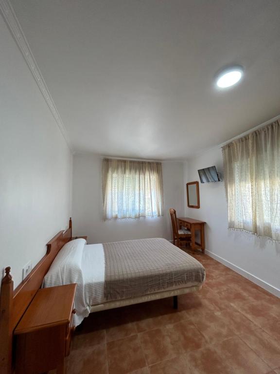 科巴罗A Casa de Santos的卧室配有一张床、一张书桌和窗户。