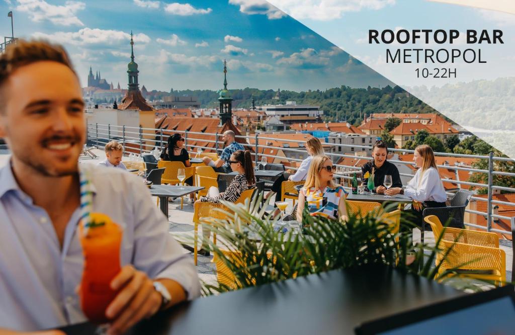 布拉格Metropolitan Old Town Hotel - Czech Leading Hotels的坐在屋顶酒吧桌子上的男人