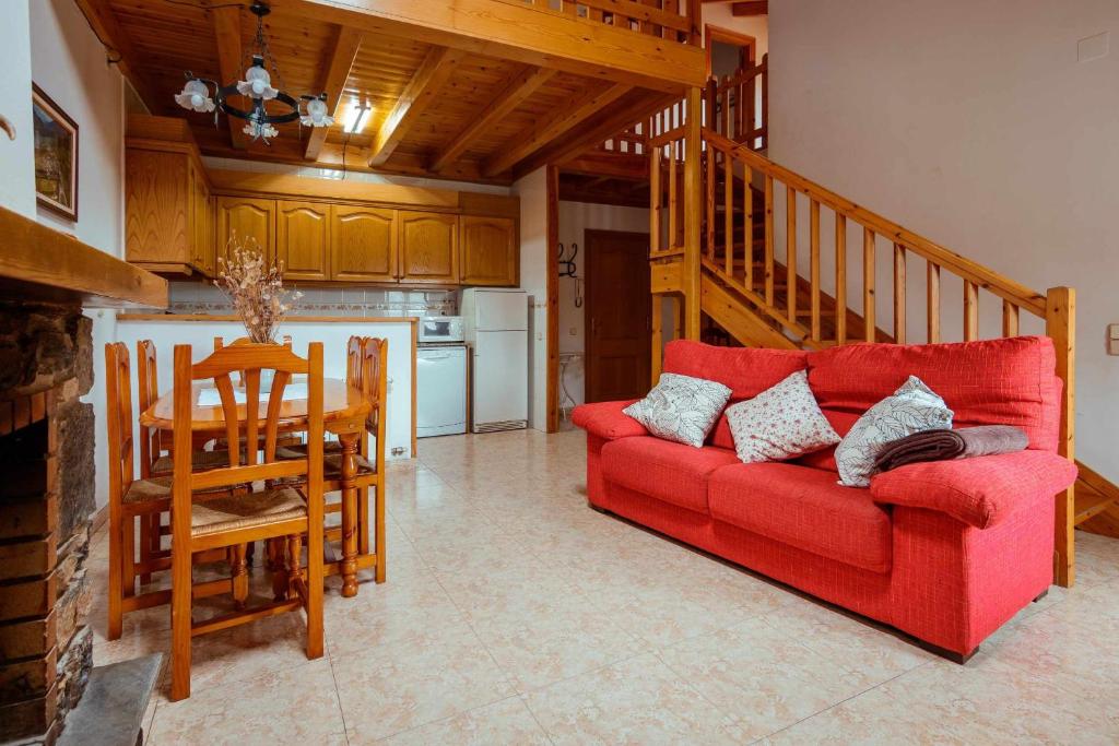 RoníCasa Xaupí 2的一间带红色沙发的客厅和一间厨房
