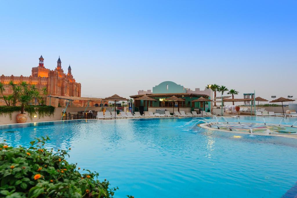 埃拉特Herods Boutique Eilat a Premium collection by Fattal Hotels的一个大型游泳池，背景是一栋建筑