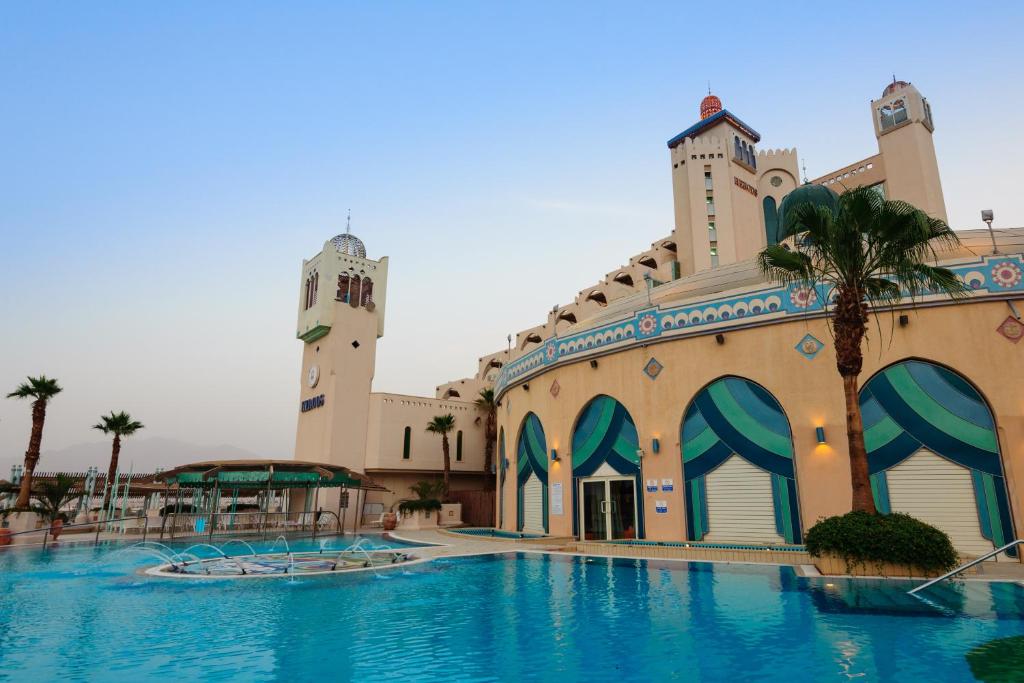 埃拉特Herods Boutique Eilat a Premium collection by Fattal Hotels的一座大型建筑,前面设有一个游泳池