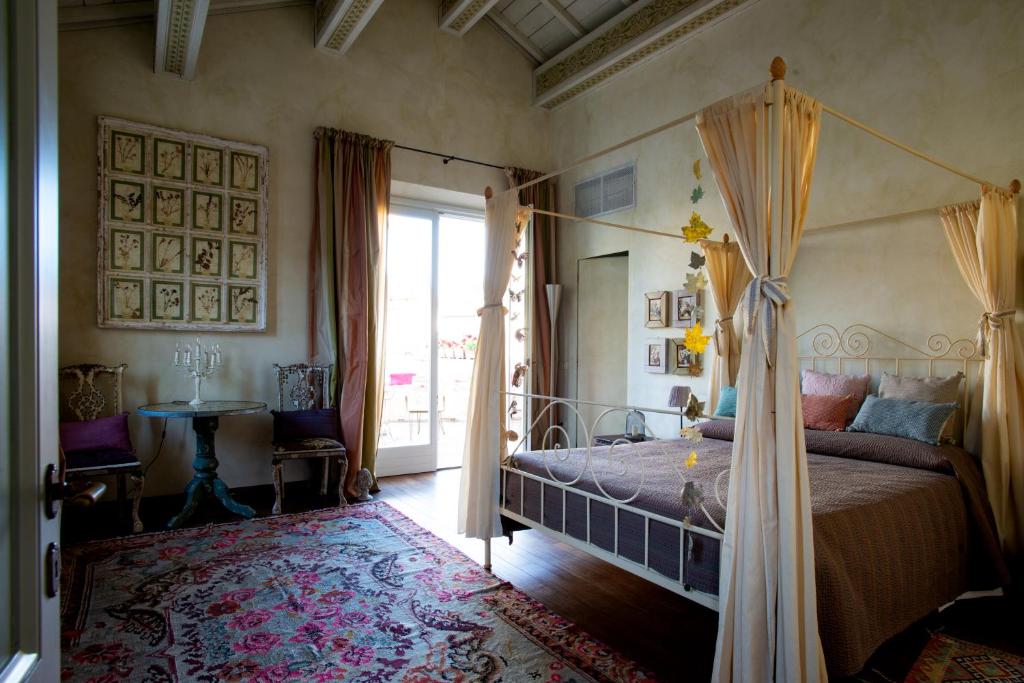 拉文纳Au petit jardin的一间卧室设有天蓬床和窗户。