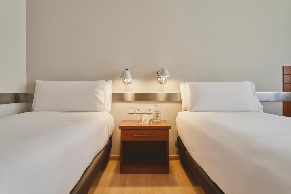 巴塞罗那特雷斯托雷斯阿迪拉姆酒店的两张睡床彼此相邻,位于一个房间里