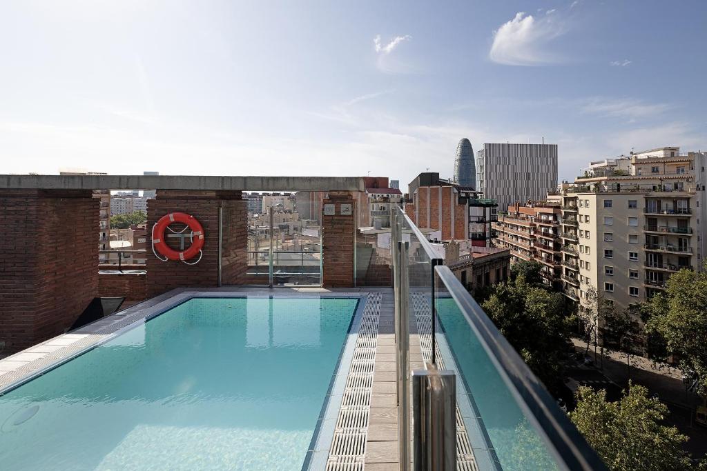 巴塞罗那加泰罗尼亚阿尔贝尼兹酒店的建筑物屋顶上的游泳池