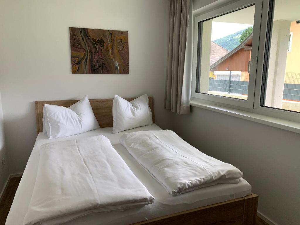 圣迈克尔隆高Ferienwohnung Siri Zentrum mit Garten的一张带白色床单和枕头的床,靠窗