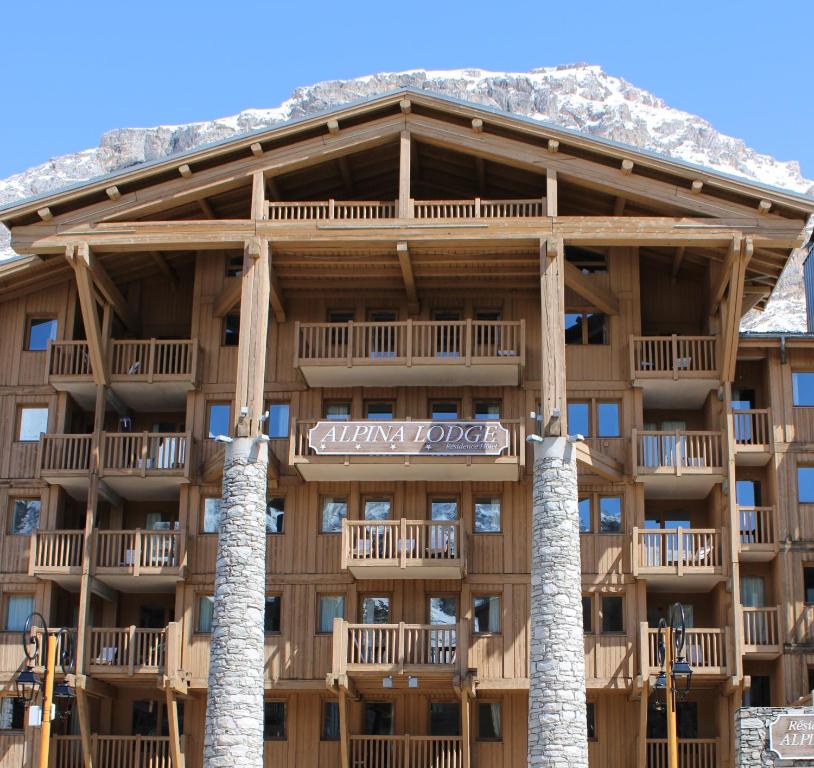 瓦勒迪泽尔Résidence Alpina Lodge by Valdiski的一座大建筑,背景是积雪覆盖的群山