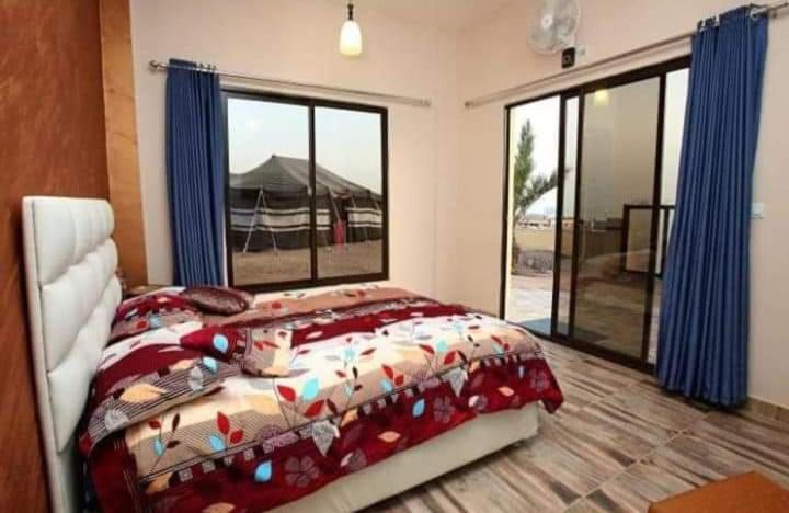 亚喀巴Bait Alaqaba dive center & resort的一间卧室设有一张床和一个大窗户